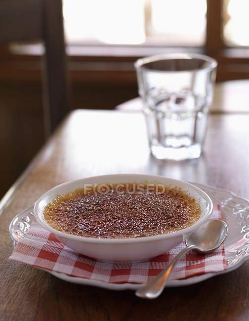 Closeup view of Creme brulee in bowl with spoon — Stock Photo