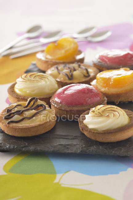 Different tartlets on ceramic tray — Stock Photo