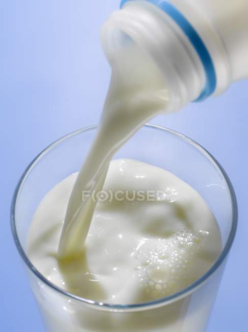 Pouring milk into glass — Stock Photo