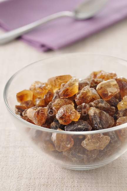 Closeup view of glass bowl of brown rock sugar — Stock Photo