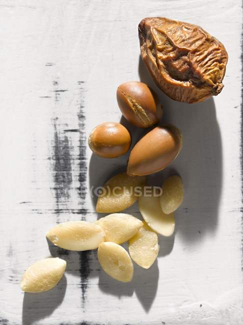 Closeup top view of Argan nuts on white shabby surface — Stock Photo