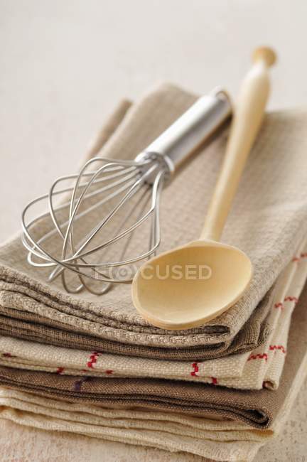 Closeup view of piled towels with wooden spoon and whisk — Stock Photo