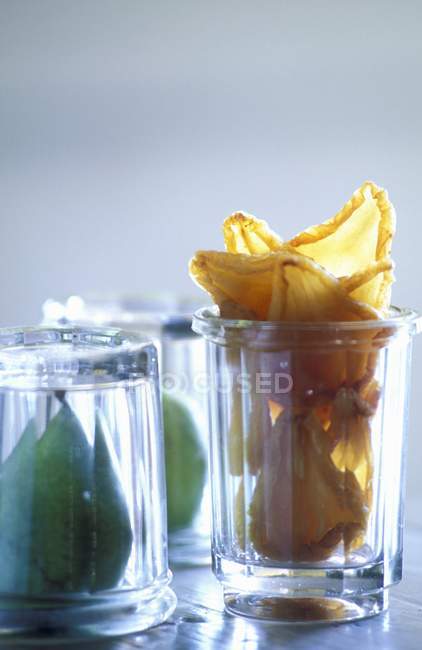 Peras frescas y secas en un vaso sobre fondo gris borroso - foto de stock