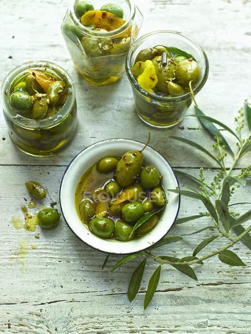 Gläser mit marinierten grünen Oliven — Stockfoto