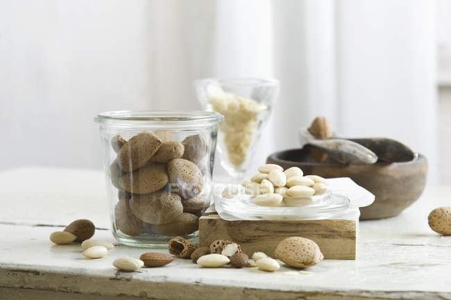 Almonds in and next to glass jar — Stock Photo