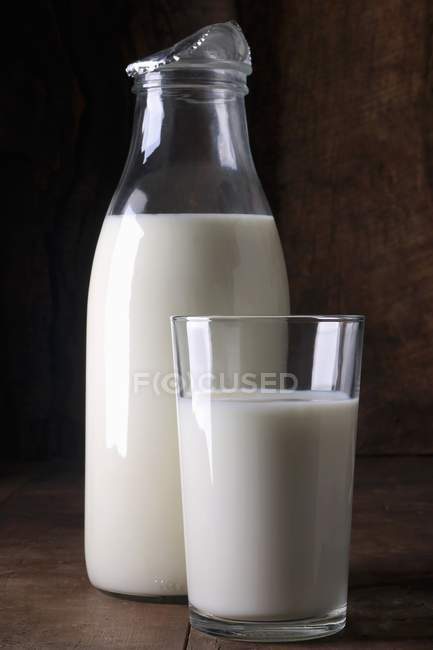 Бутылка и стакан молока — стоковое фото