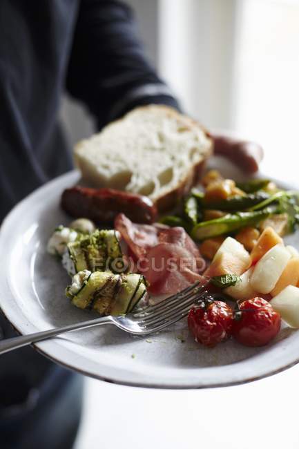Sunday brunch plate with fork in hand, midsection — Stock Photo
