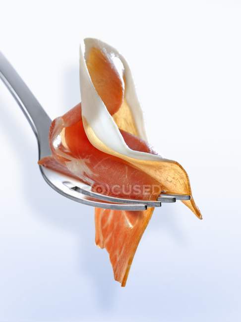 Slice of raw ham on fork — Stock Photo