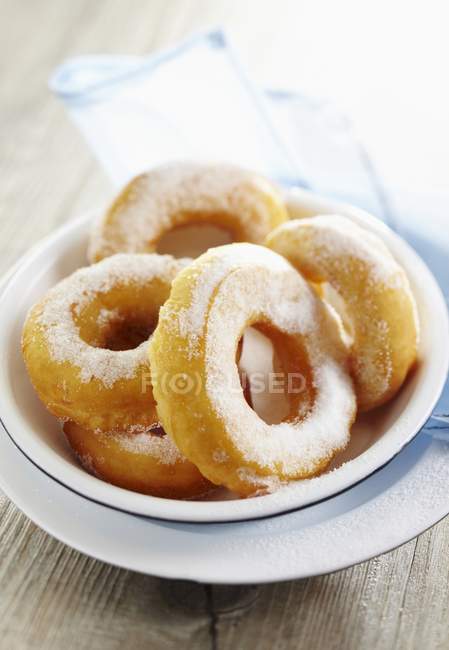 Donuts de azúcar apilados en tazón - foto de stock