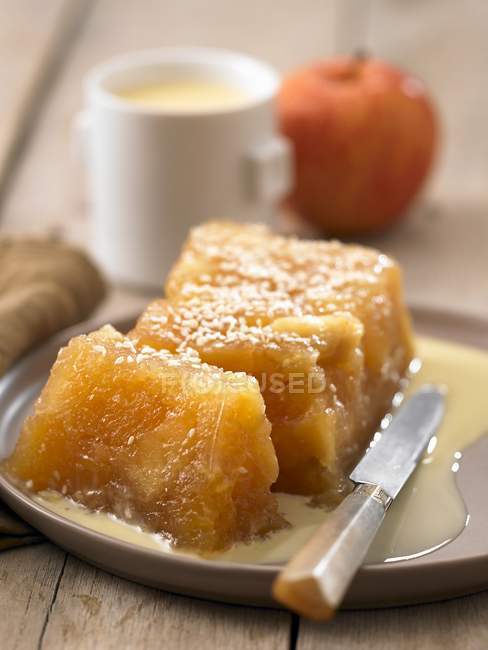 Apple terrine on wooden desk with knife on plate — Stock Photo