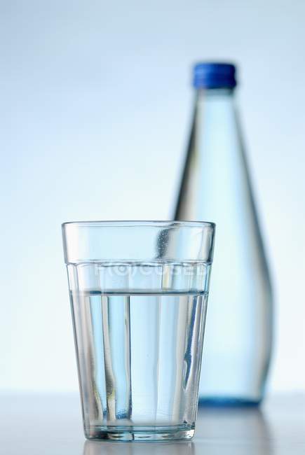 Closeup view of glass and bottle of water — Stock Photo