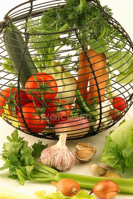 Basket of fresh vegetables on white surface — Stock Photo
