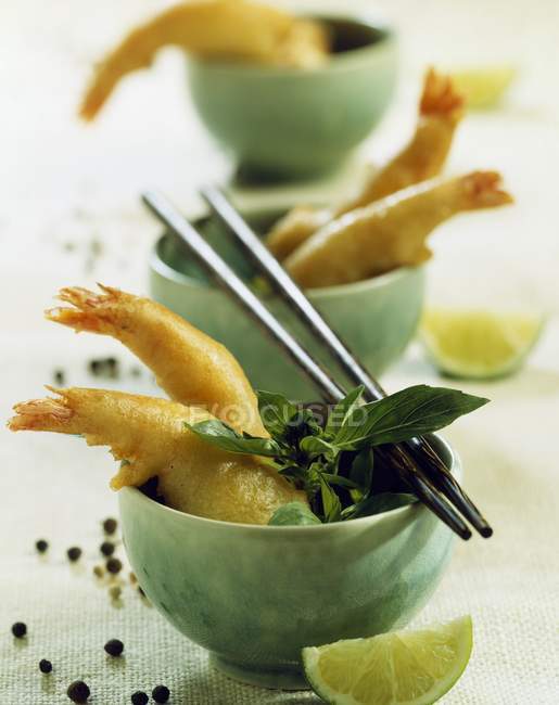 Closeup view of shrimp fritters with basil and chopsticks on bowls — Stock Photo
