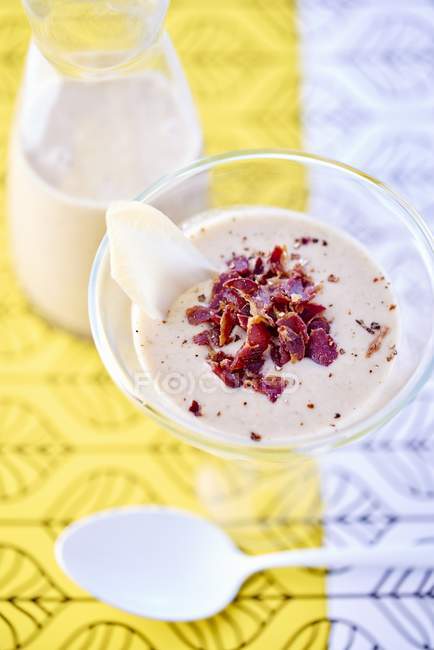 Cream of chicory soup in glass over tablecloth — Stock Photo