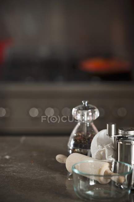 Closeup view of pepper caster with rolling pin, glass bowl and pepper mill — Stock Photo