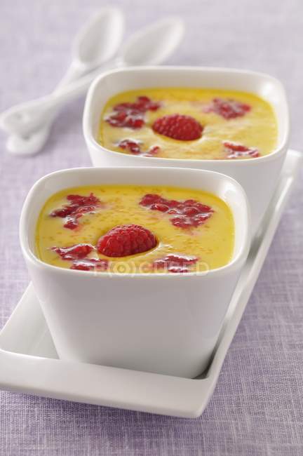 Custard with raspberries in bowls — Stock Photo