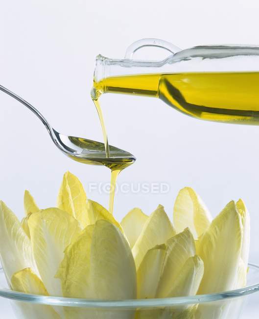 Оливкова олія і цикорій в скляній мисці — стокове фото