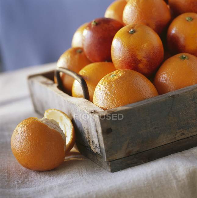 Wooden tray of fresh oranges — Stock Photo