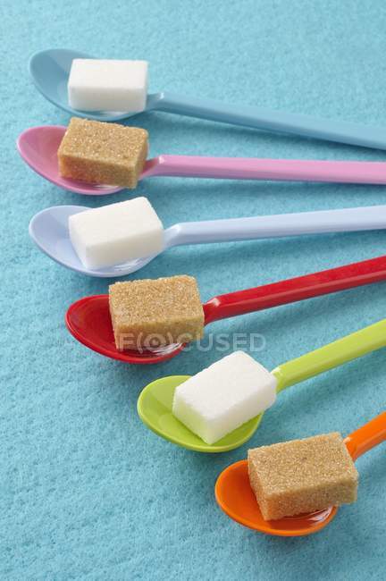 Spoons with white and brown sugar lumps — Stock Photo