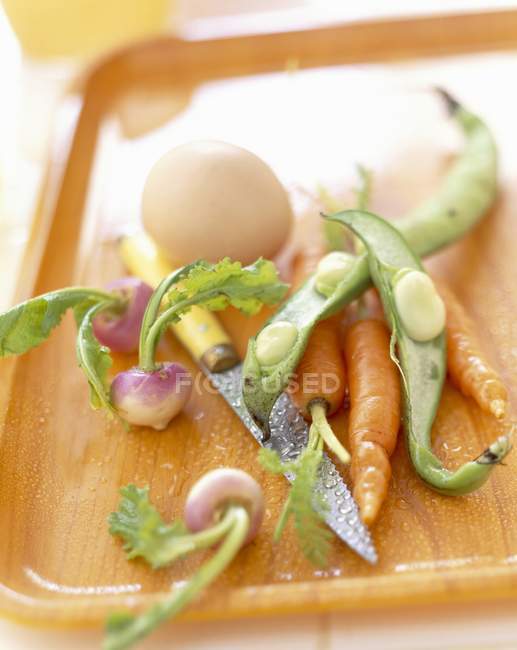 Pelado de verduras en bandeja con cuchillo - foto de stock