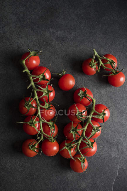 Fresh ripe tomatoes on black background — Stock Photo