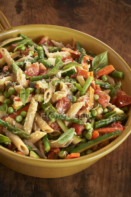 Penne with spring vegetables and cheese in large bowl — Stock Photo