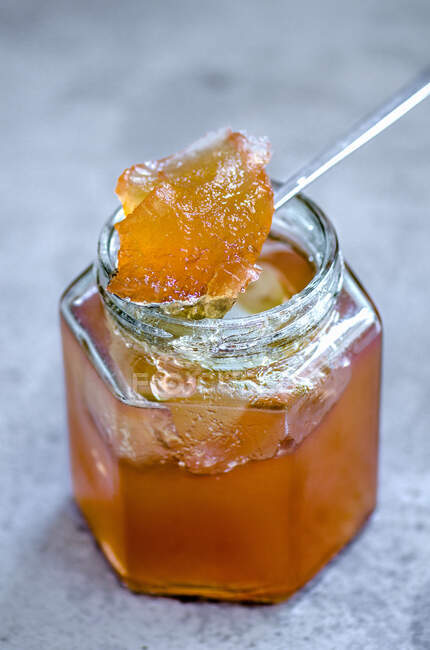 Jam in small glass jar and on spoon — Stock Photo