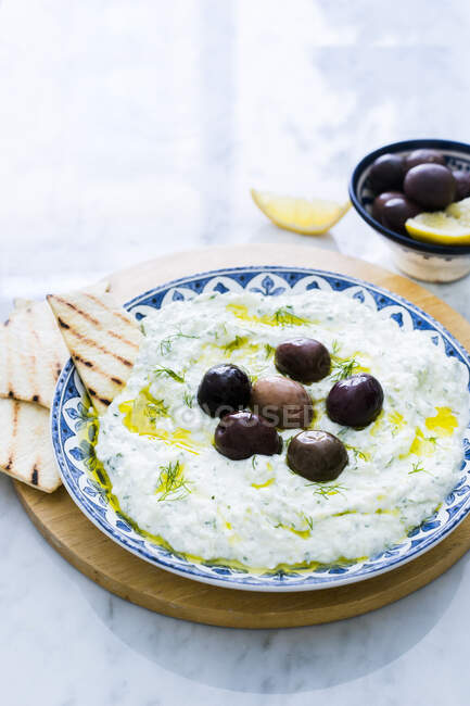 Tzatziki with olives and grilled bread — Stock Photo