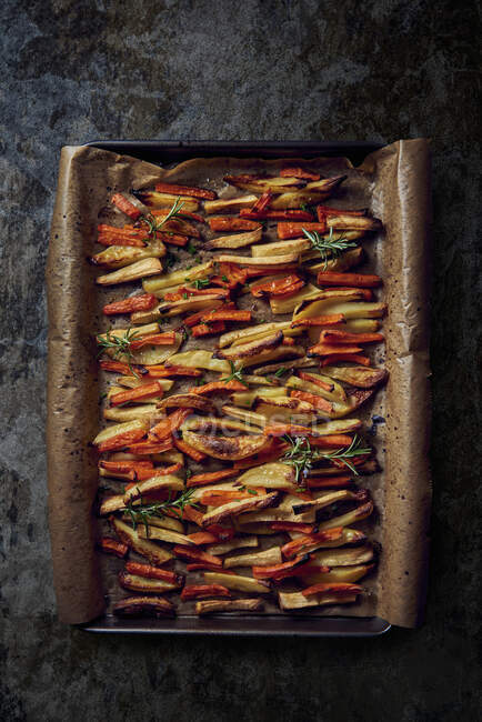 Roasted vegetables (carrots, potatoes) on a baking tray — Stock Photo