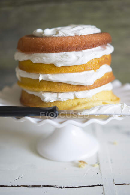 Layer Cake with cream and knife — Stock Photo