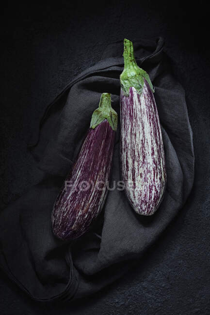 Two aubergines on a black cloth — Stock Photo
