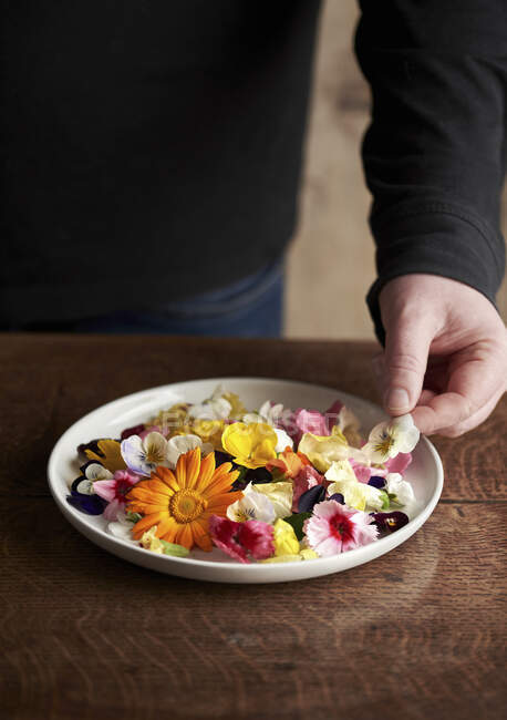 Чоловік робить їстівний квітковий салат — стокове фото