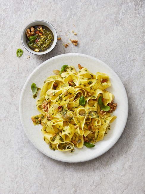Tagliatelle with garlic and basil pesto, walnuts, pine nuts and basil leaves — Stock Photo