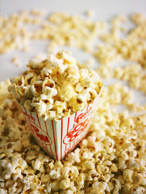 Popcorn in a glass bowl on a white background — Stock Photo