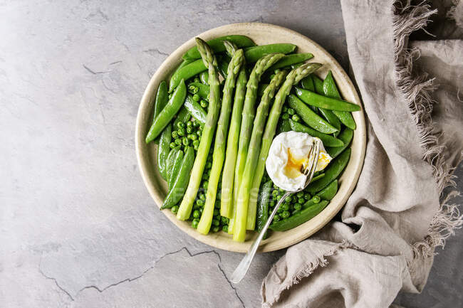 Variety of cooked green vegetables asparagus, peas, pod pea, served with bread and poached egg — Stock Photo