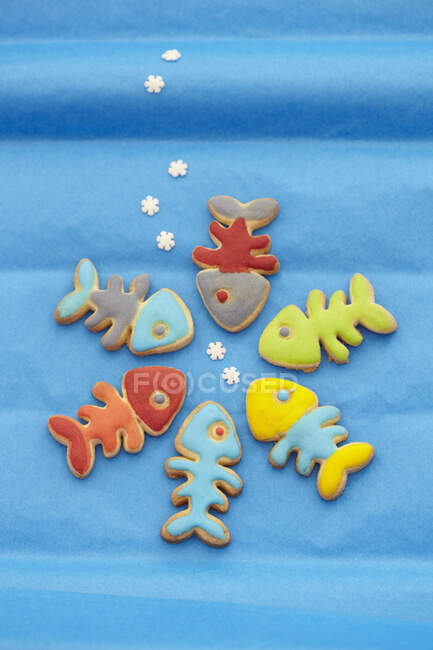 Fish shaped biscuits with colorful icing on blue background — Photo de stock