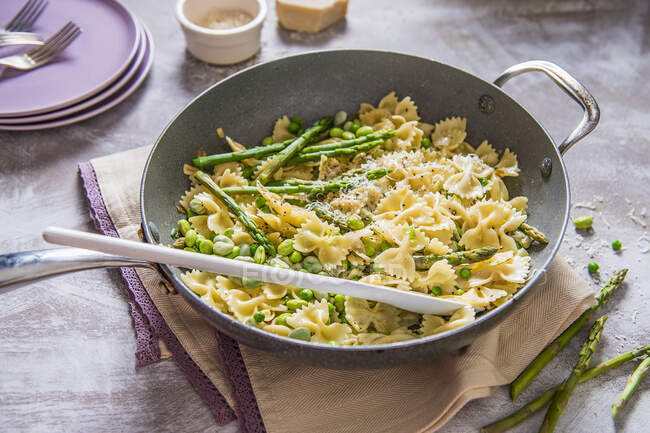 Spring pasta with cream sauce, peas, beans, asparagus and parmesan cheese — Stock Photo