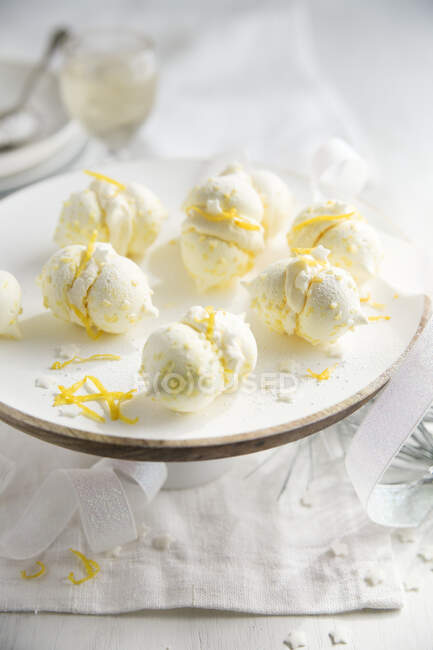 Lemon meringues with zest on stand at decorated table — Stock Photo
