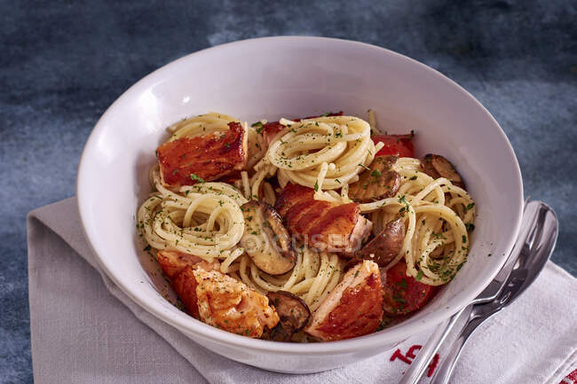 Спагетти с лососем, грибами и помидорами — стоковое фото