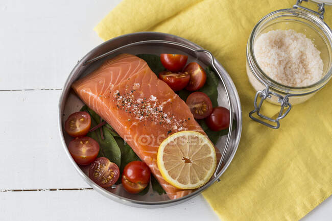 Salmón y tomates en una olla a presión - foto de stock