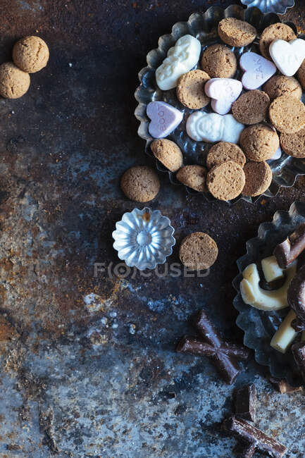 Various cookies in metal trays and on rustic surface — Stock Photo