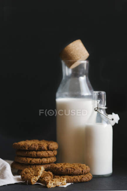 Oat cookies and milk in jug and bottle — Stock Photo