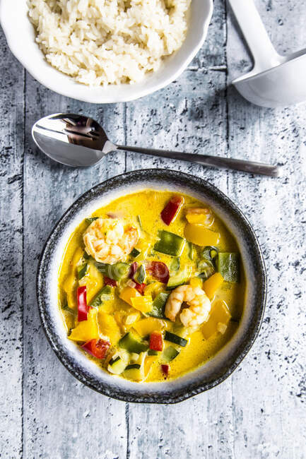 Thai curry made with pepper, mange tout, courgettes, coconut milk and prawns served with rice — Stock Photo