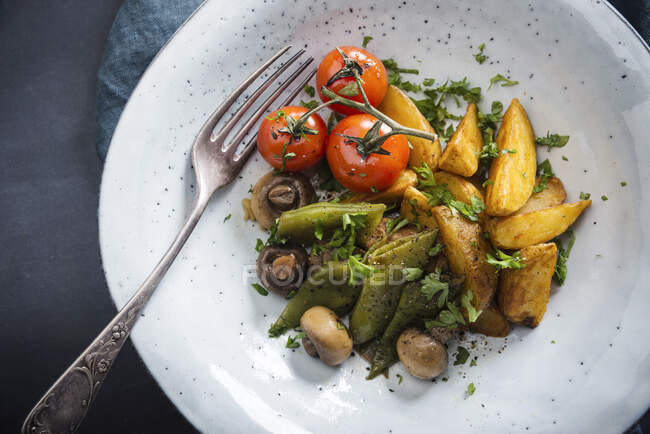 Заработная плата за выпечку картофеля с зеленой фасолью, грибами и помидорами (вегетарианская) — стоковое фото