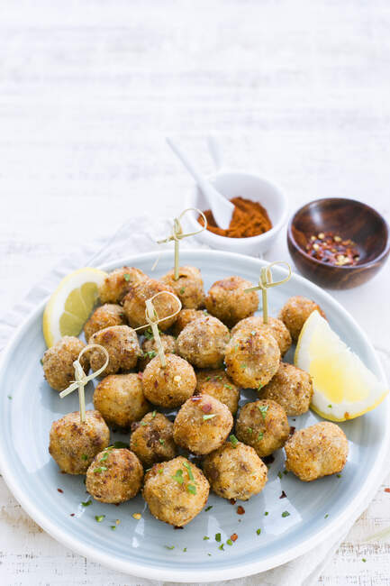 Pepper and chili fish balls with lemon on plate — Stock Photo