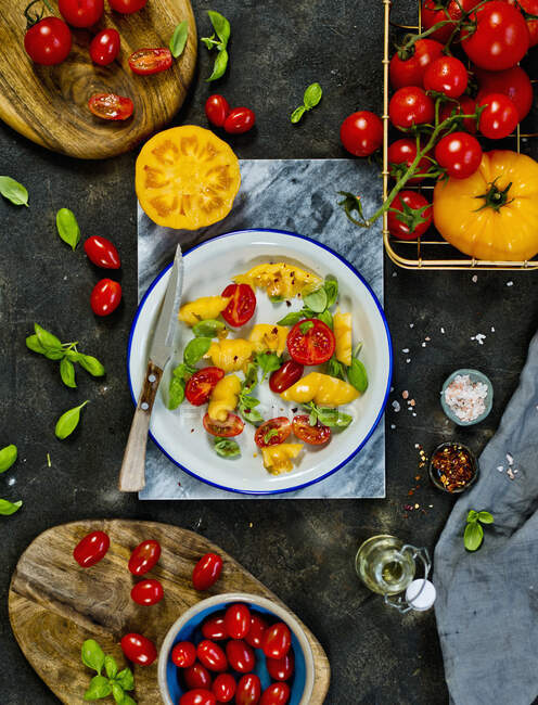 A salad of yellow and red tomatoes with basil — Stock Photo