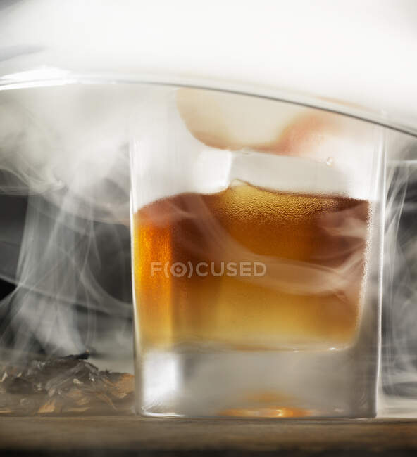 Cóctel Old Fashioned rodeado de humo - foto de stock