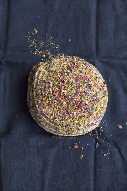 A loaf of wholemeal bread topped with edible flowers — Stock Photo