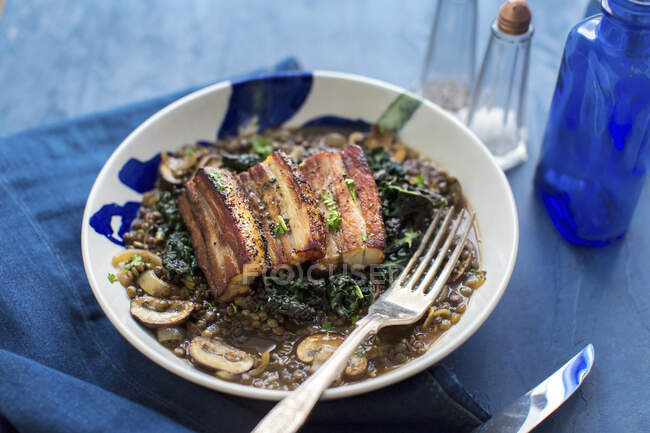 Pork belly on lentils with mushrooms and cabbage — Stock Photo