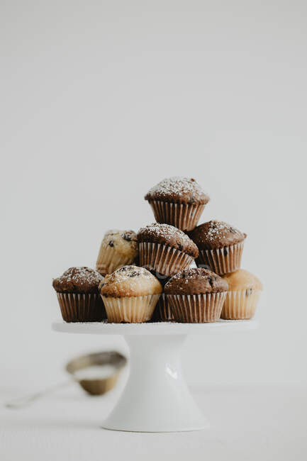Mini muffins avec des gouttes de chocolat sur un stand de gâteau — Photo de stock